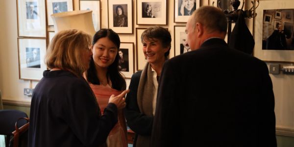 Four people in conversation in an art-filled room.