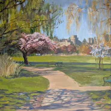 A serene park scene with blossoming trees and empty benches.