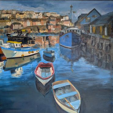 Boats floating peacefully in a harbor with houses in the background.