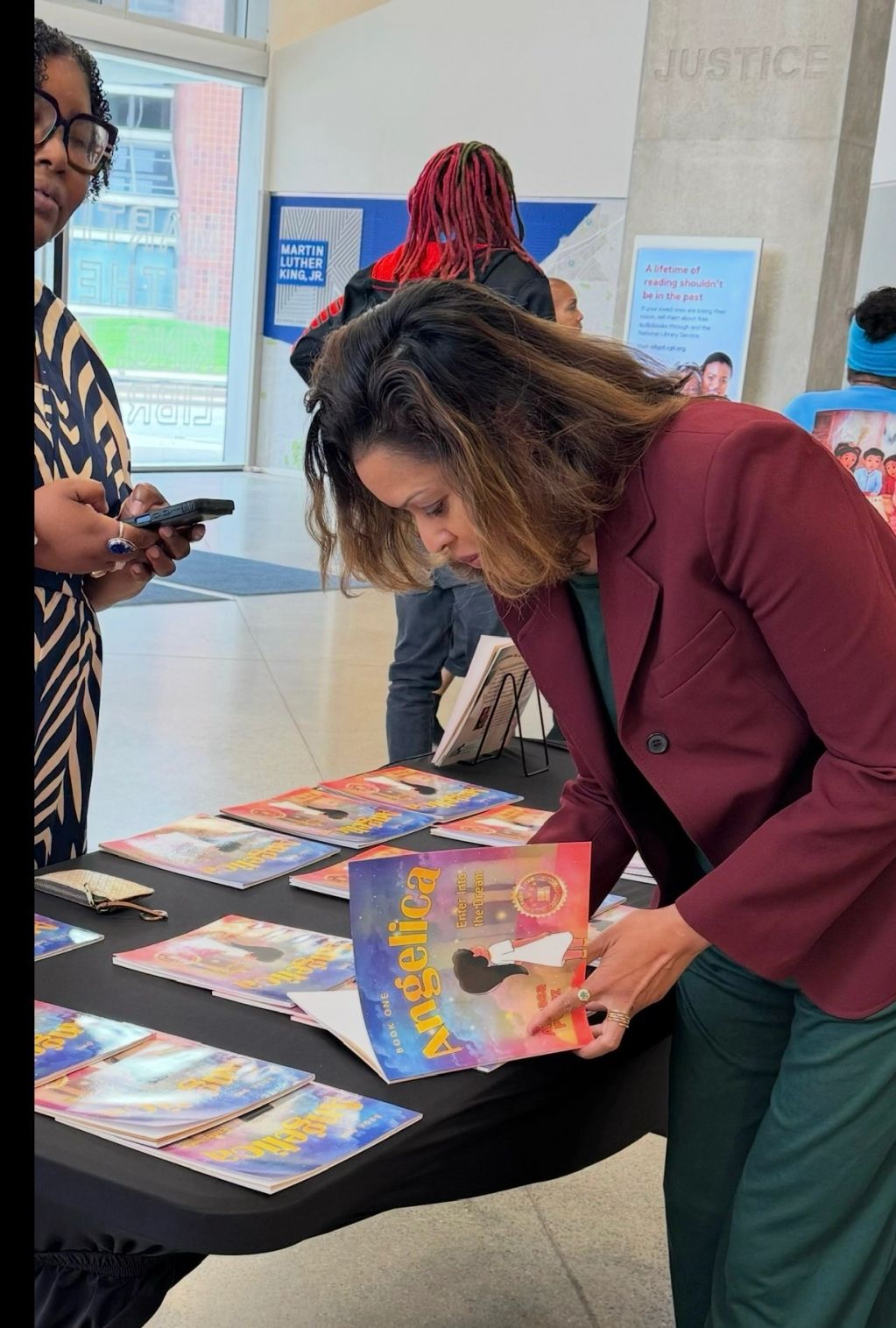 Woman looking at books on a table at an event.