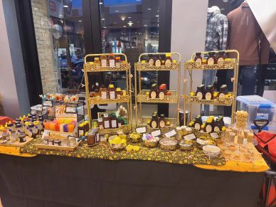 A honey and beeswax product display at a market stall.
