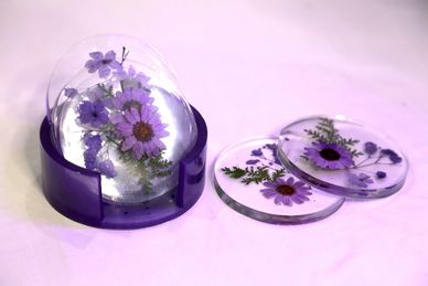 Purple floral resin coasters with embedded flowers and a matching holder.