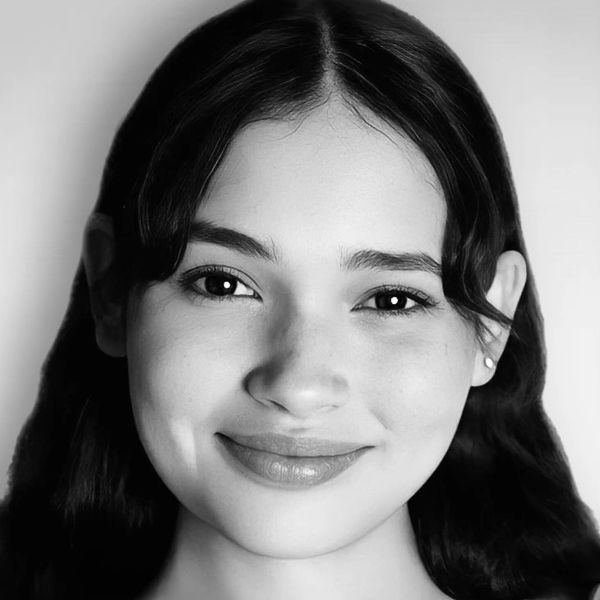 Close-up black and white portrait of a smiling woman.