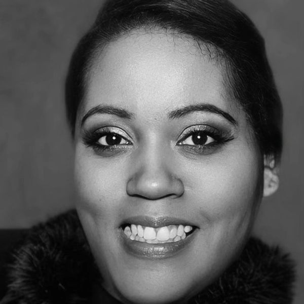 Close-up black and white portrait of a woman smiling.