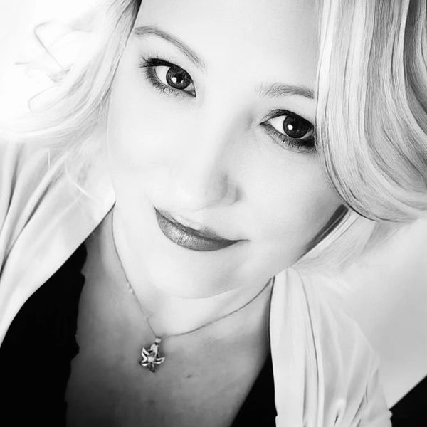 Black and white close-up portrait of a smiling woman.