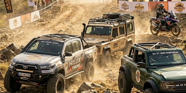 Off-road vehicles and a motorcycle navigating a rocky dirt trail during a 4x4 championship event.