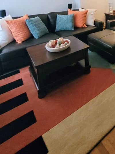 Cozy living room with brown leather sofa and colorful cushions.