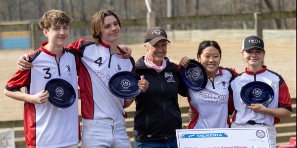 Four young athletes hold awards, standing with a smiling woman outdoors.