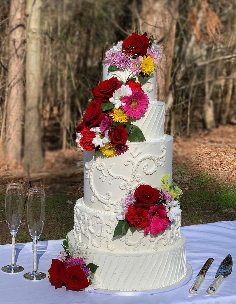 white five tier double barrel wedding cake hand piping cascading fresh florals 