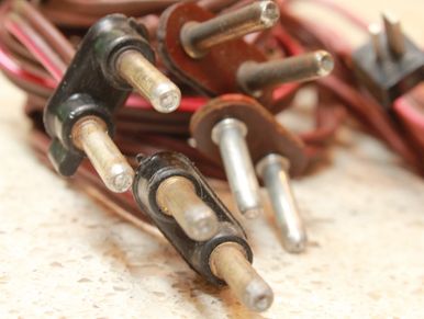 Close-up of old electrical plugs with metal prongs.