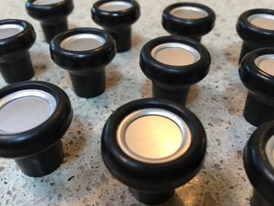 Close-up of black and silver buttons arranged on a table.