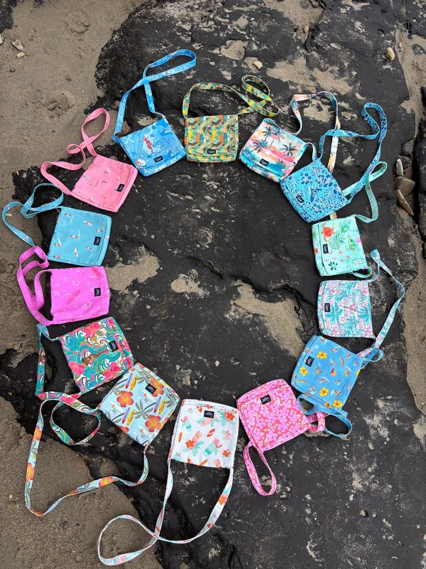 Colorful small bags arranged in a circular pattern on rocky sand.