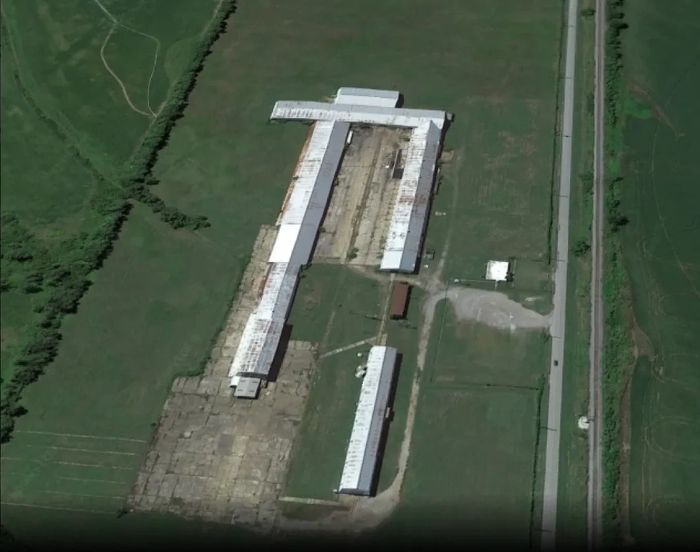 Aerial view of an industrial or agricultural facility with multiple long buildings.