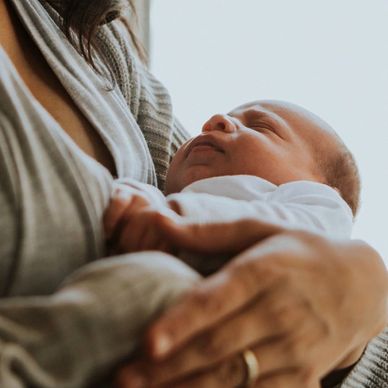 A mother holding her sleeping newborn