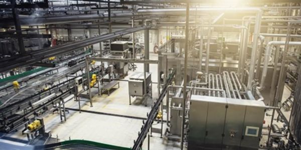 Modern industrial factory interior with machinery and conveyor belts.