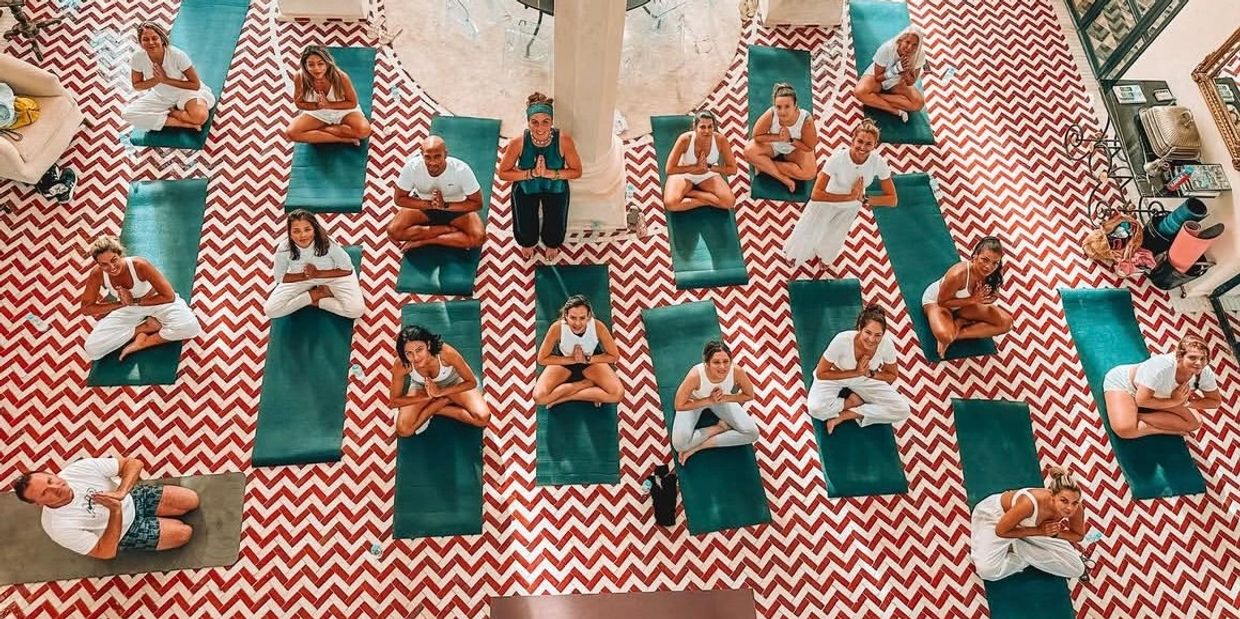 group practicing yoga inside a traditional Moroccan villa in Essaouira, authenticity and culture."