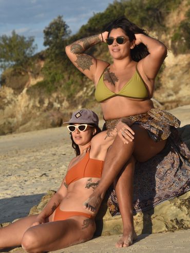 Two cool girls posing at the beach with very nice bathing suits. 