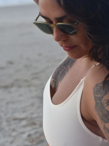 Brunnette woman wearing a very comfortable beige bikini top, size L.