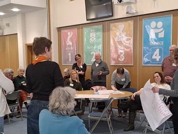 A group of people engaged in a meeting or workshop in a room.