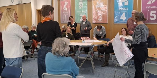A group engaged in a community meeting or workshop in a casual setting.