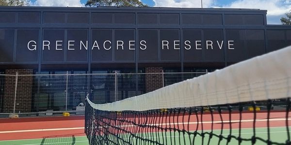 Tennis court at Greenacres Reserve under blue sky.