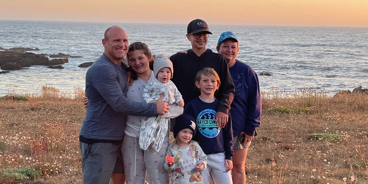 Group of people, a family, at the ocean at sunset