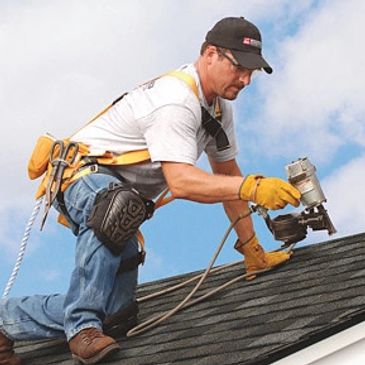 A roofer installing shingles. 