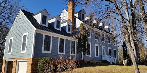 Large gray house with multiple dormer windows.