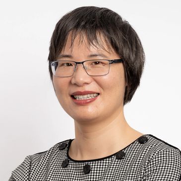 Smiling woman with glasses and short hair.
