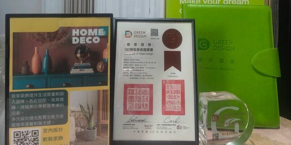 Awards and promotional materials for Green Design and Home Deco displayed on a table.