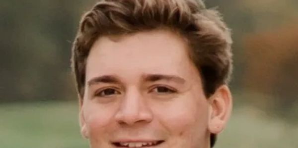 Close-up of a smiling young man with short brown hair.