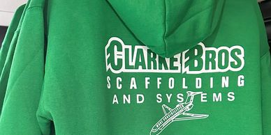 Green hoodie with Clarke Bros Scaffolding and Systems logo and airplane graphic.