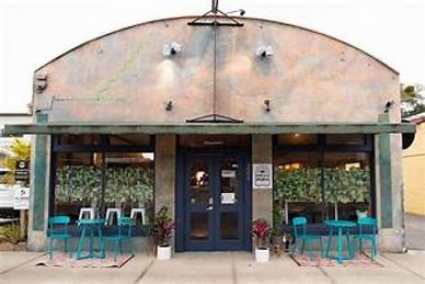 Cozy café with outdoor seating and green-themed decor.