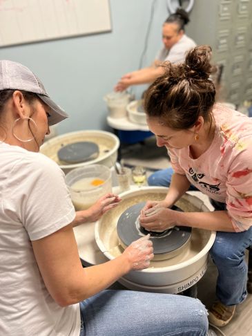 Two women engaged in pottery making.