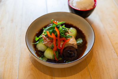 A bowl of chinese style marlin served with bok choy, shitake mushrooms, and a side of white rice.