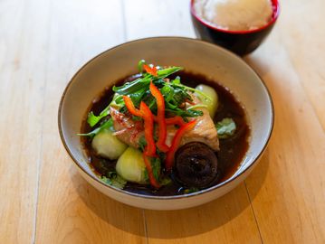 A bowl of chinese style marlin served with bok choy, shitake mushrooms, and a side of white rice.