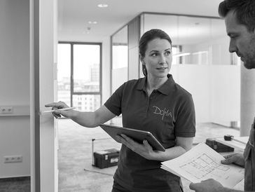 Two professionals discussing building plans in an office setting.