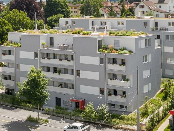 Modern apartment building with rooftop gardens and balconies.