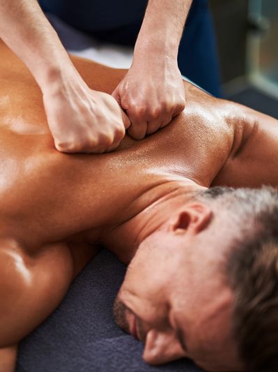 A massage therapist using deep tissue techniques to relieve upper back tension
