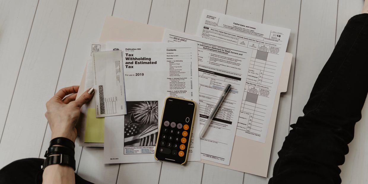 Woman sitting on the floor looking at different tax documents