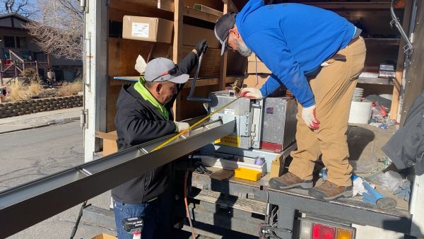 The Easy Rain Gutter Installation Crew cutting a seamless gutter on-site in Salt Lake City.