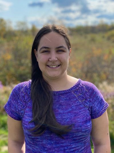 Audrey Lavoie smiling white woman with long dark brown hair and brown eyes and a purple short sleeve