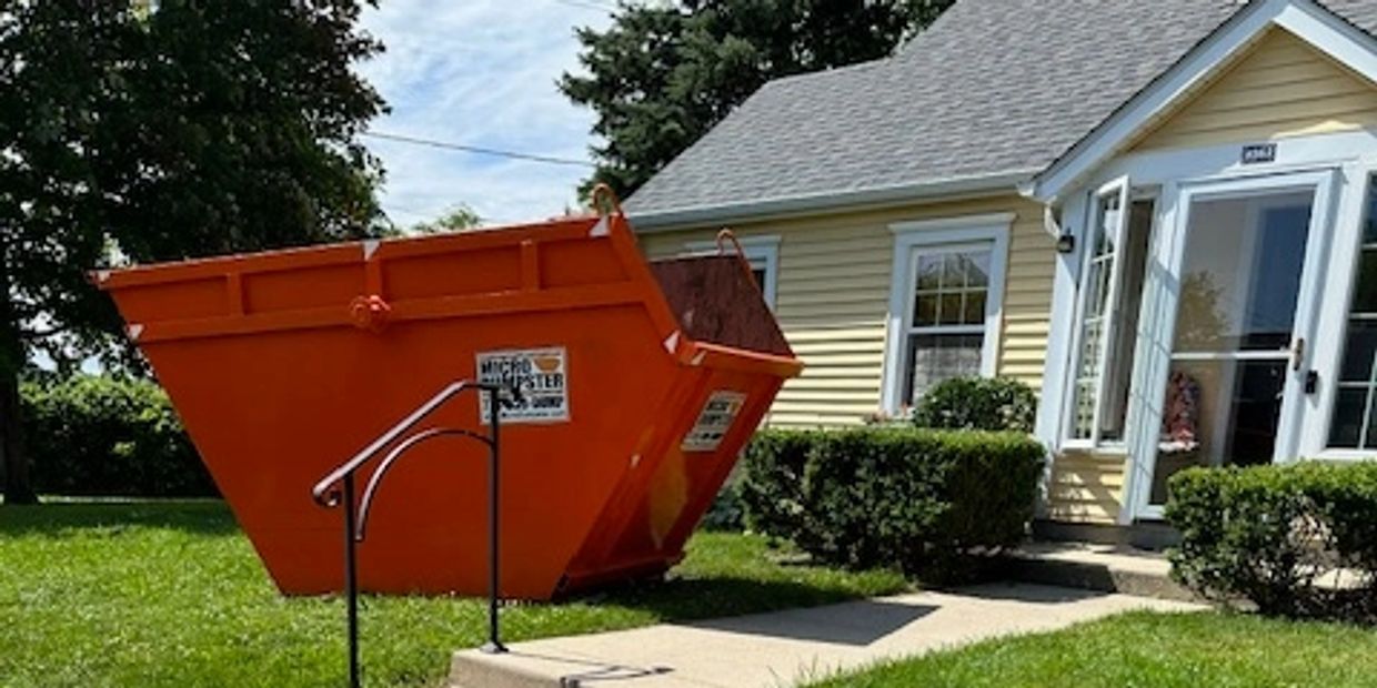 JUNK Dumpster mini dumpster on the grass near the sidewalk in Morton Grove