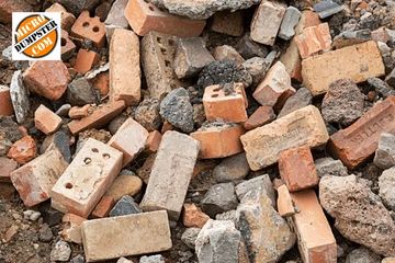 Pile of mixed rubble consisting of concrete, asphalt, and bricks ready to be loaded and hauled away