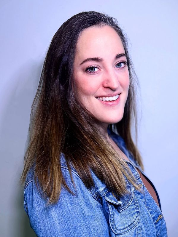 Smiling woman in a denim jacket.
