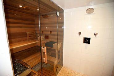 Modern sauna with wooden interior and glass door.