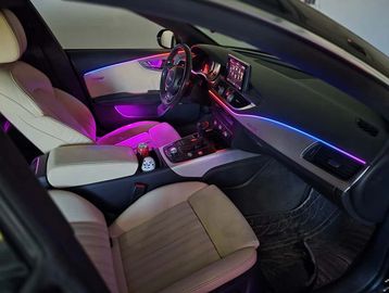 Modern car interior with ambient LED lighting and beige seats.