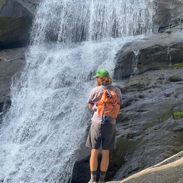 Man standing in front of waterfall