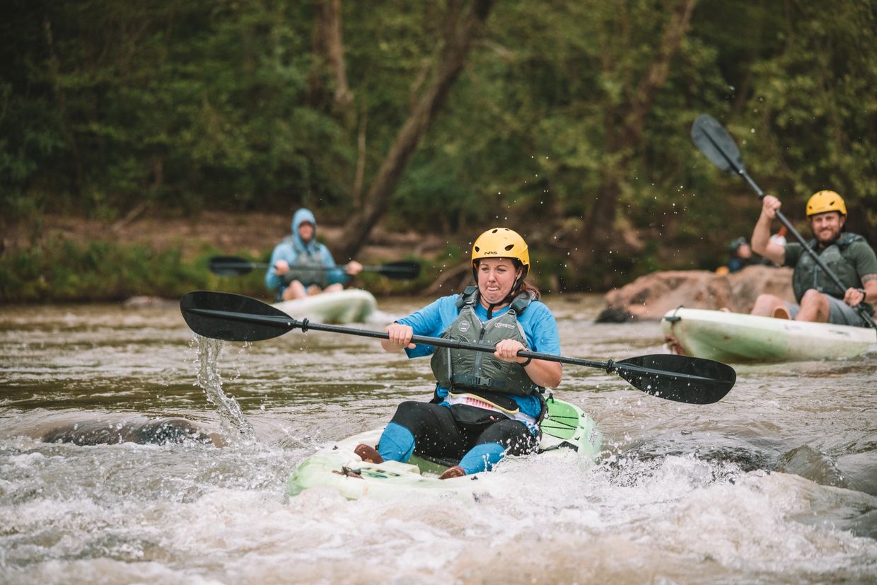 Kayakers paddling through rapids