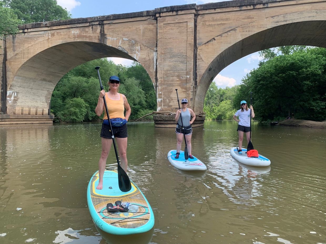 3 women stand up paddleboarding